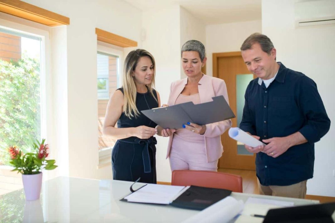 People standing around looking at documents illustrating how to negotiate on house price